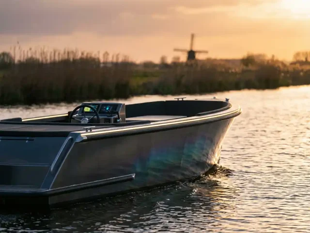 Moderne aluminium sloep vaart door kalme polderwaters met LED-verlichting en minimalistisch dashboard bij zonsondergang
